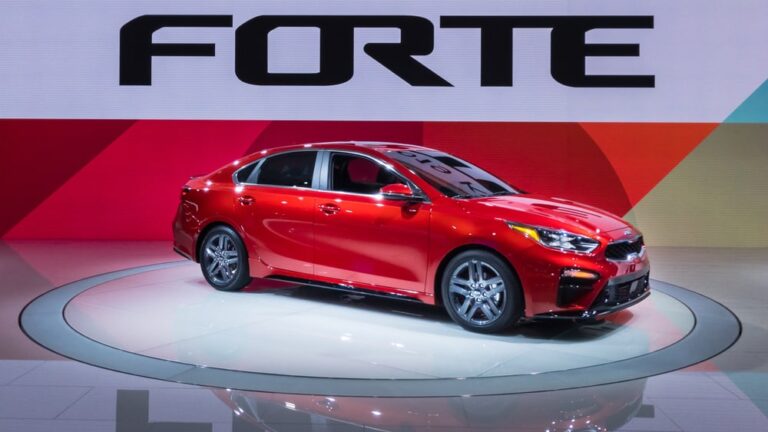 This is a red Kia Forte on display at a car show.