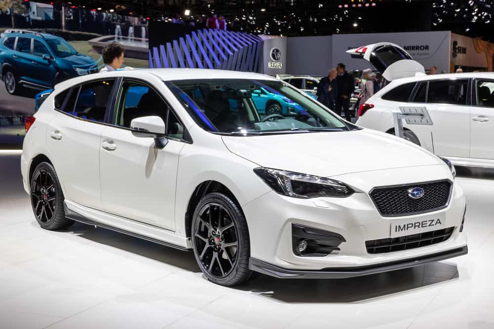 This is a white Subaru Impreza on display at a car show.