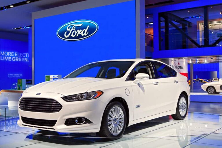 This is a white Ford Fusion on display at a car show.