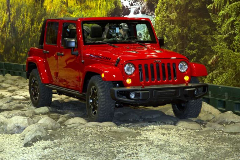 This is a red Jeep Wrangler on display at a car show.