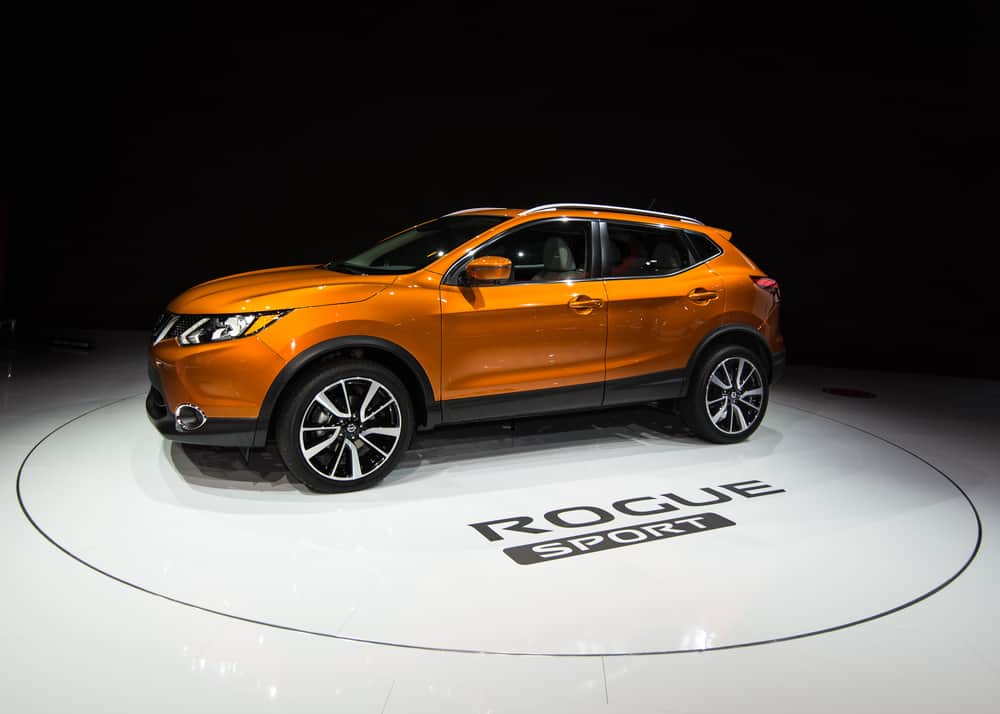 This is an orange Nissan Rogue Sport on display at a car show.