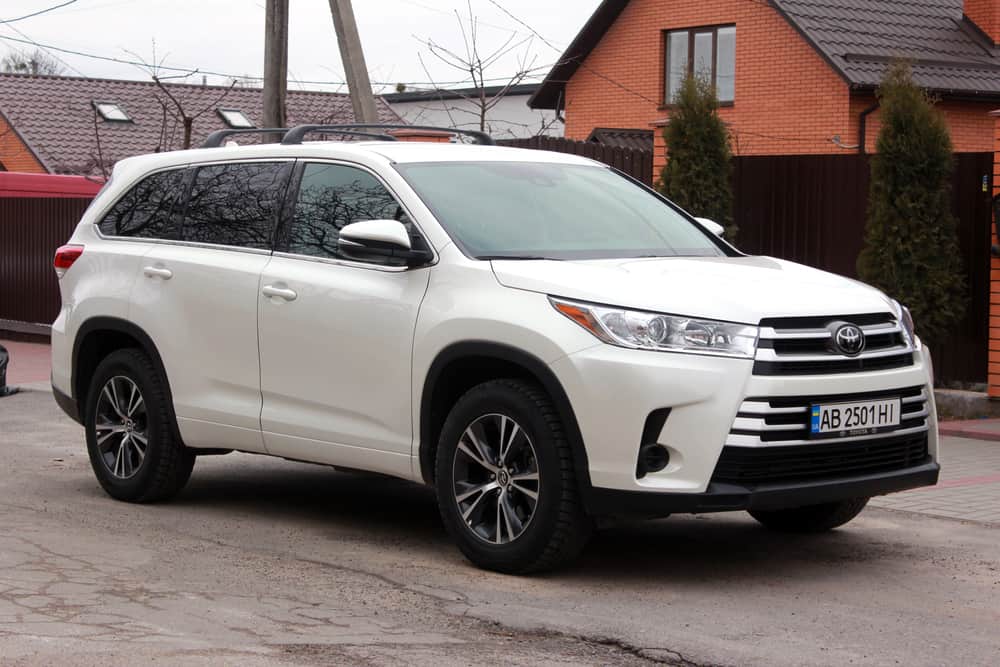 This is a white Toyota Highlander parked on the side of a residential street.