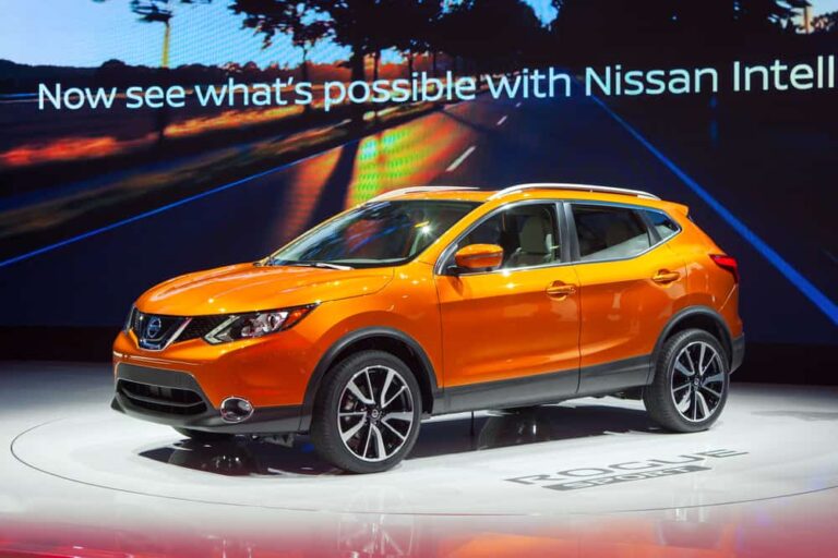 This is an orange Nissan Rogue on display at a car show.