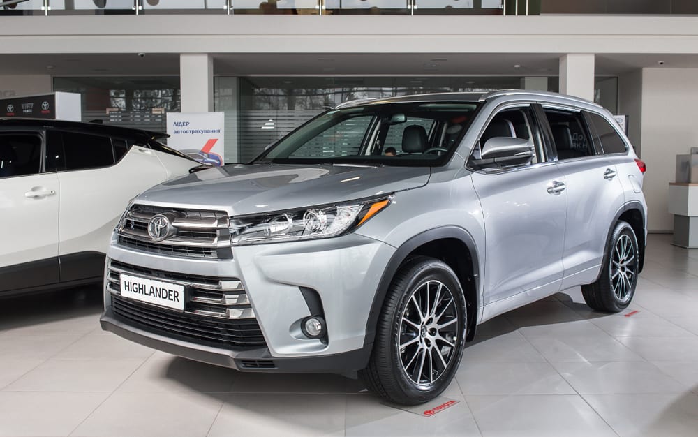 This is a silver Toyota Highlander on display at a car show.