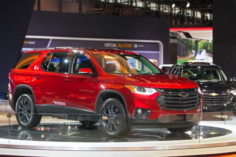 This is a red Chevrolet Traverse on display at a car show.