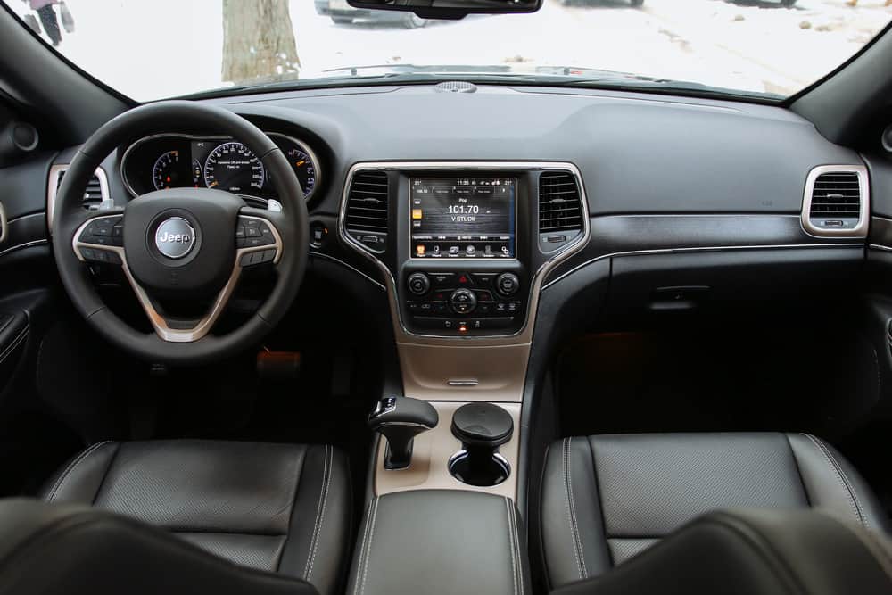 This is a close look at the interior of a Jeep Grand Cherokee showcasing the front seats and dashboard.