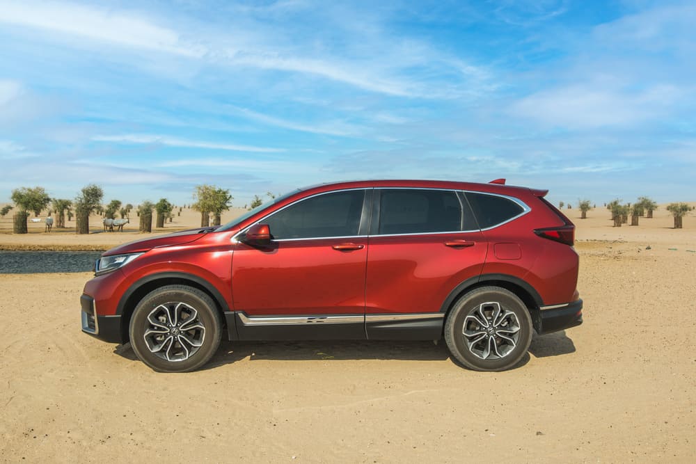 This is a red Honda CR-V parked on a desert landscape.