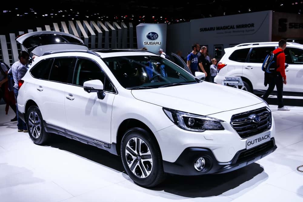 This is a white Subaru Outback at a car show.