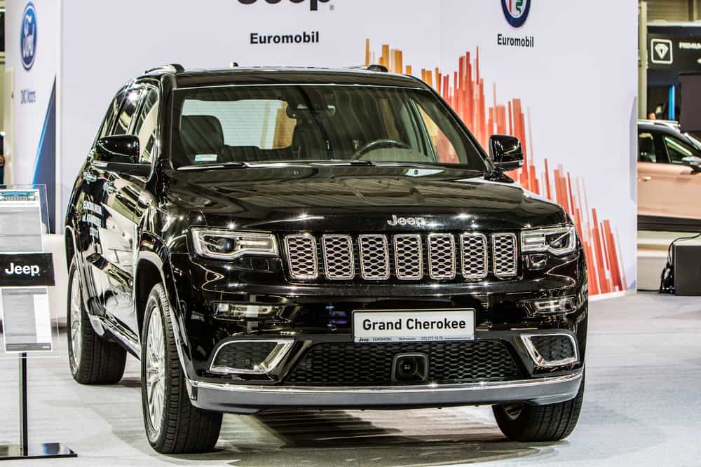 This is a black Jeep Grand Cherokee on display at a car show.