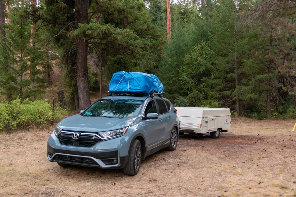 This is a Honda CR-V with a roof cargo along with a trailer in tow.