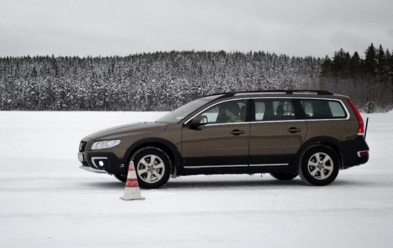 This is a brown Volvo XC70 on a snowy road.