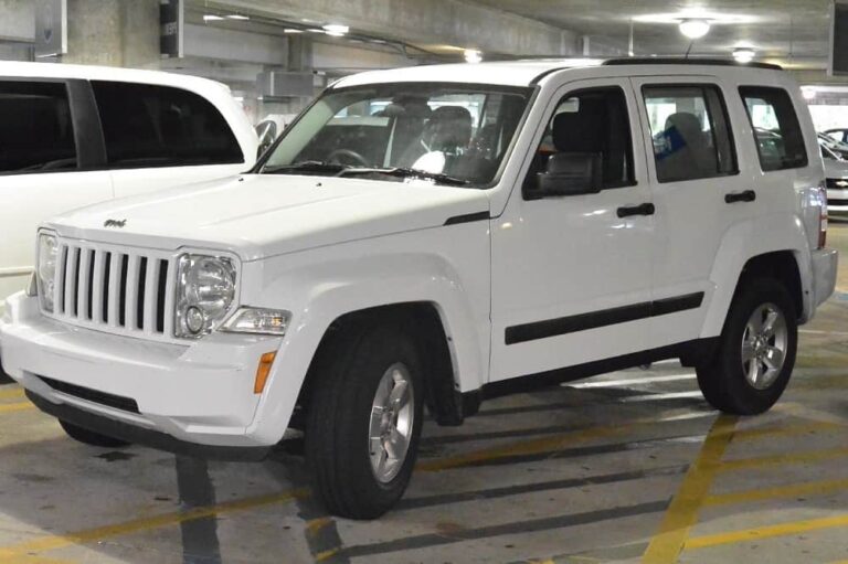 This is a white Jeep Liberty parked in a covered parking area.