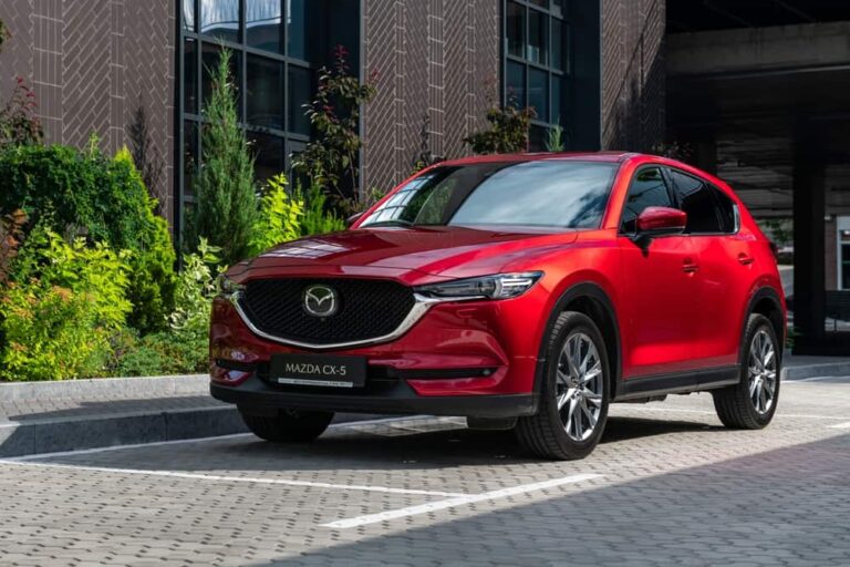 Front view of a red Mazda CX5 parked in front of a building.