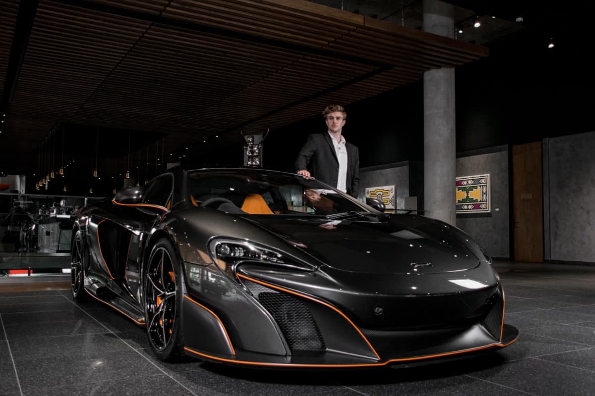 Man standing beside his luxury car.