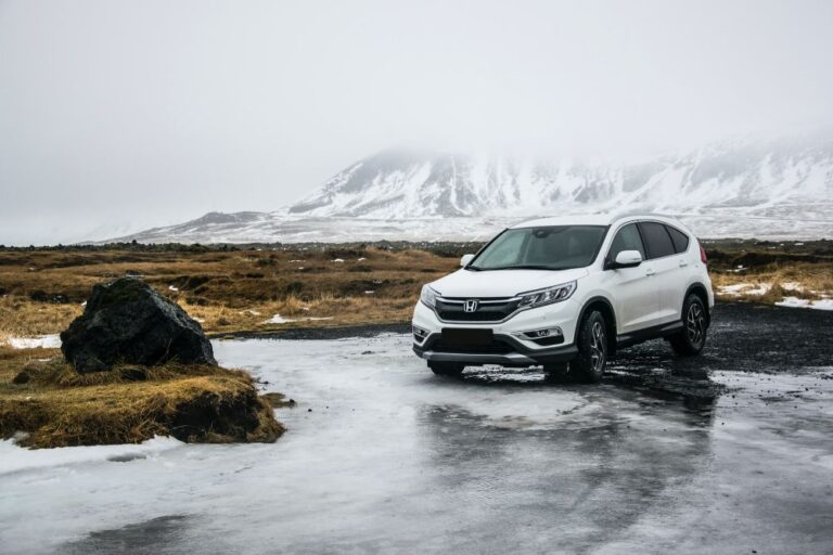 White Hinda Pilot car beside the river near the mountain hill.