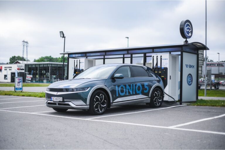 A blue Honda Ioniq 5 near a waiting shed.