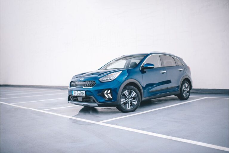 A blue Kia Niro in a parking space.