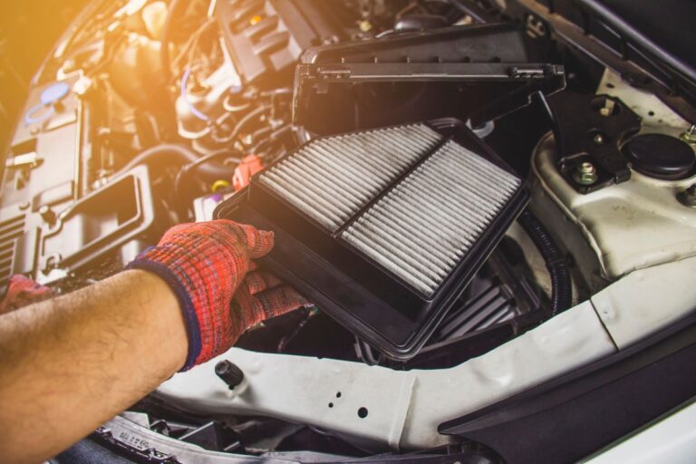 A mechanic changing a car's air filter.