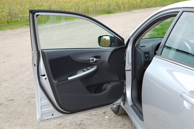 A car parked with its driver's seat door open.