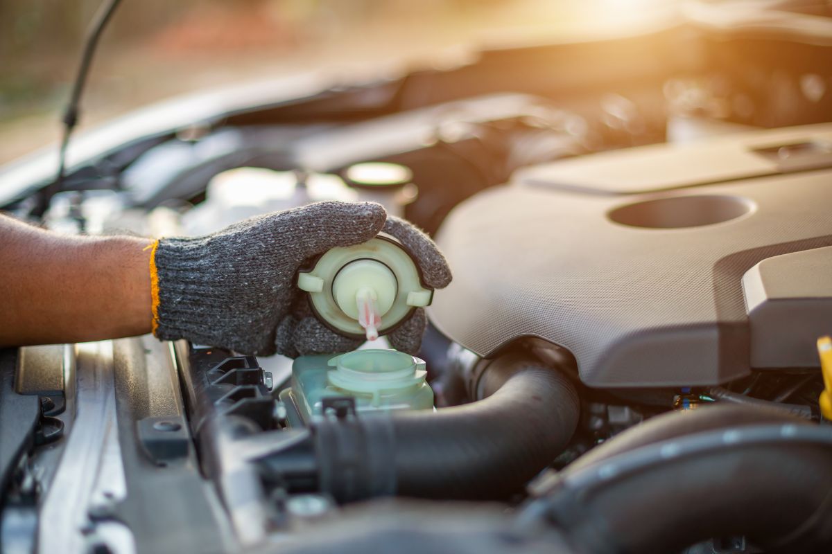 A car mechanic checking his car if it needs a cooland or transmission coolant.