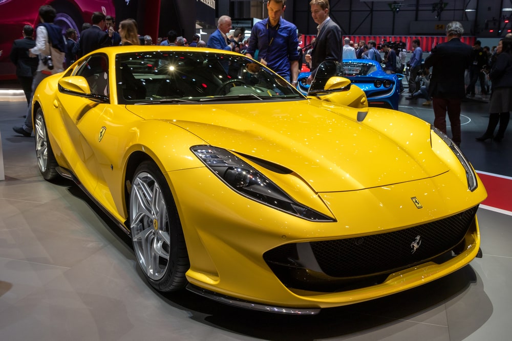 Yellow Ferrari 812 Superfast, displayed on a showroom.