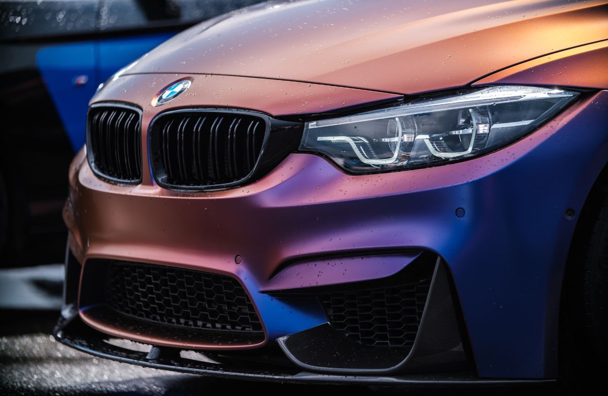 Front spoiler of purple matte BMW M3 F80 vehicle.