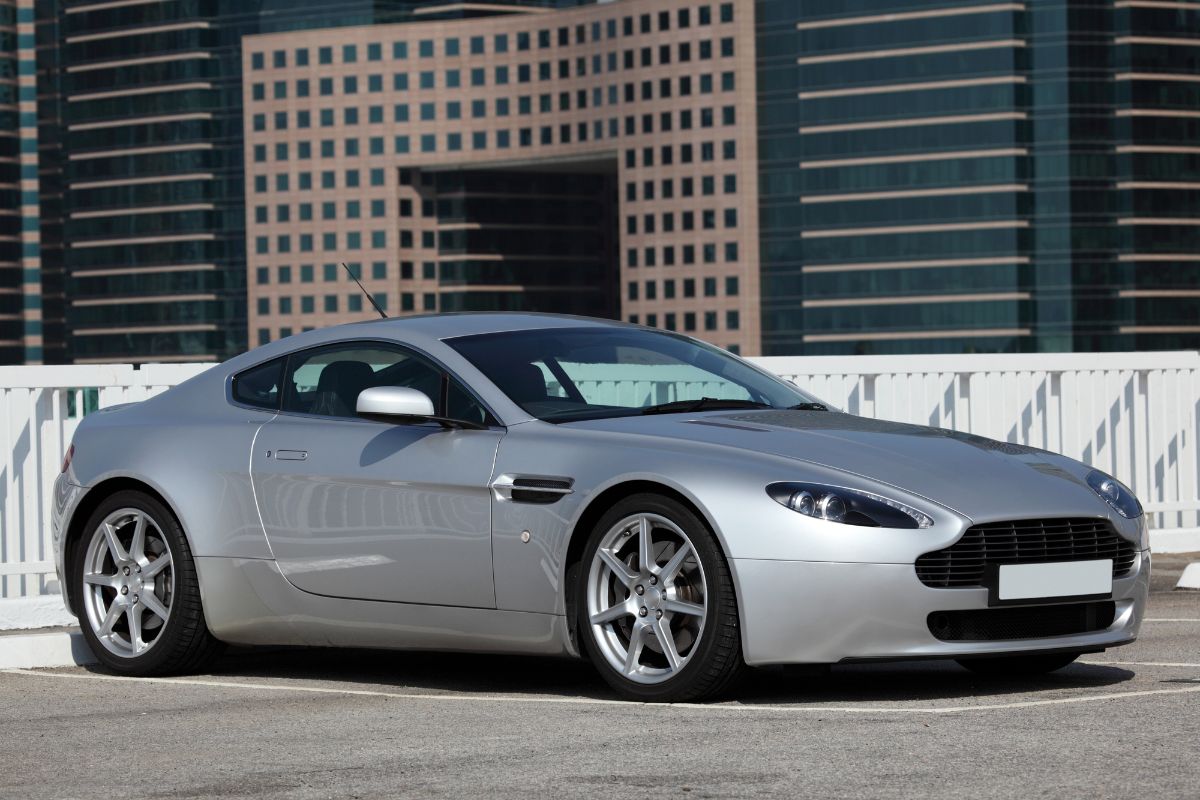 Gray Aston Martin Vantage parked in front of the building.