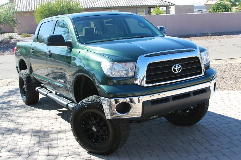 Green Toyota Tundra parkin on the bricks floor open area.  