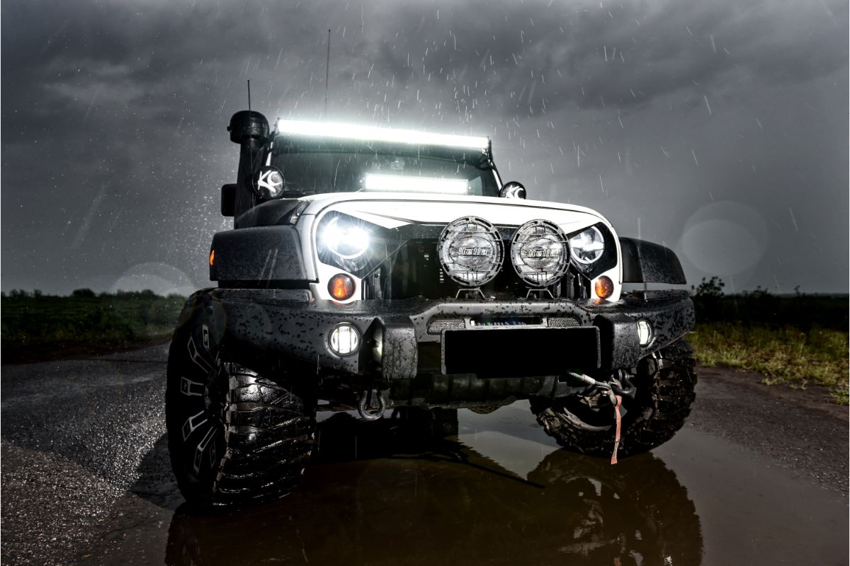 Front view of a black wrangler with lights on.