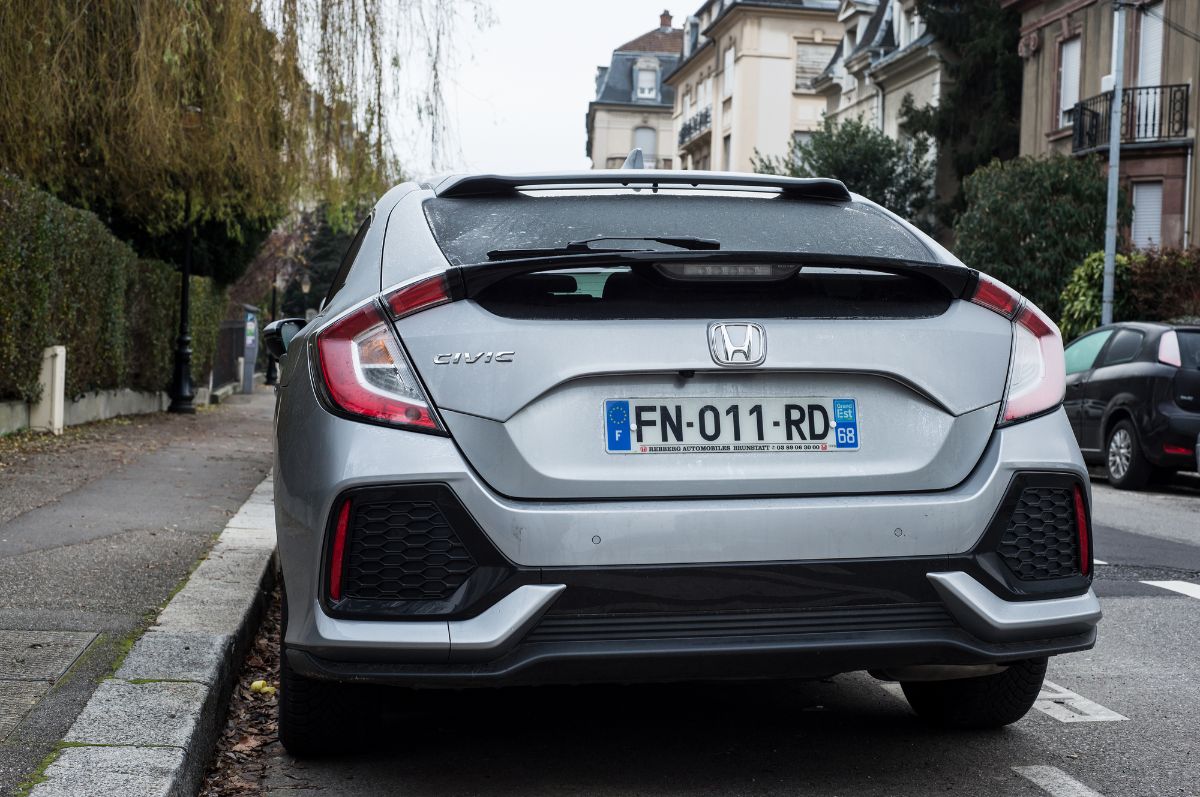 Lip spoiler of grey Honda Civic car parked in the street.