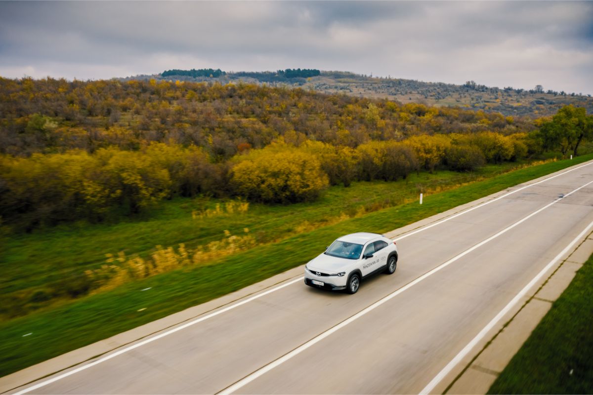 Top view shot of a white moving car on the road.