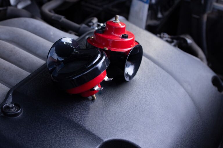 Red car horn on top of the car's engine.