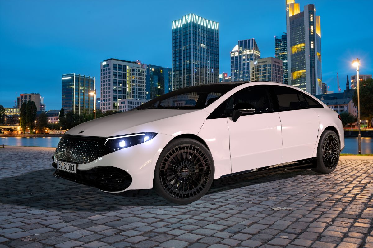 Side view shot of a white Mercedes Benz EQS against the city background.