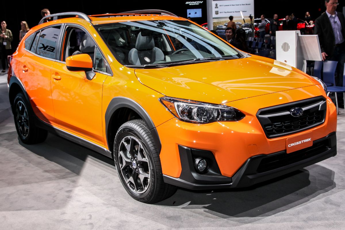 Front view of yellow Subaru Crosstrek Hybrid on car show.