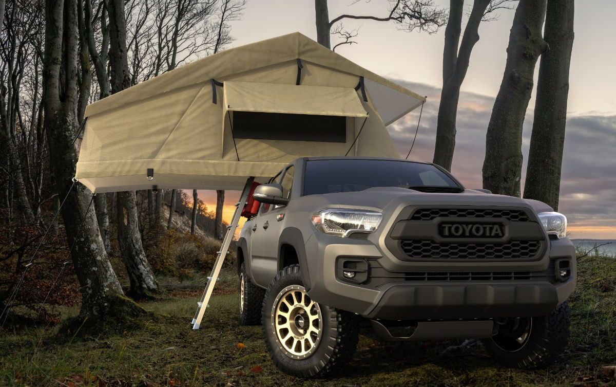 A toyota tacoma infront of a tent.