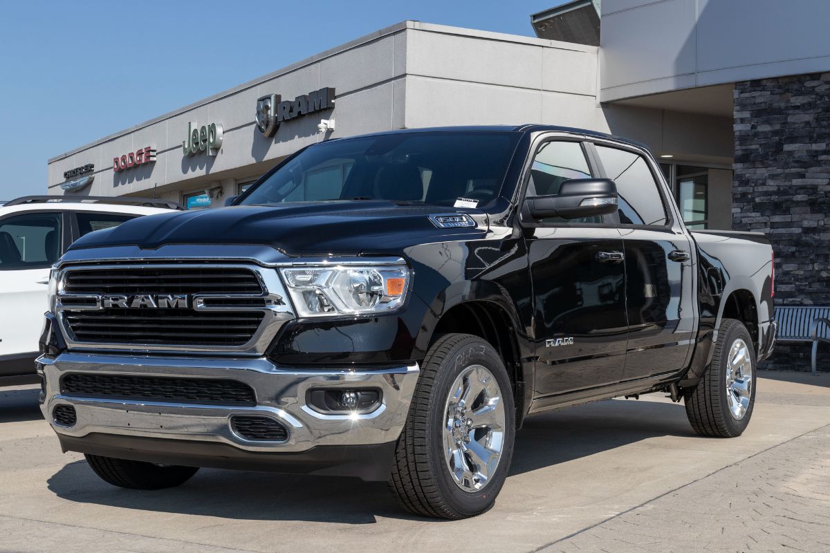 A front view of a RAM 1500 parked near a car store.