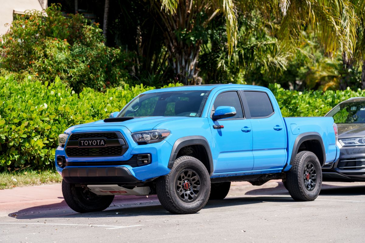 A side view of a blue 2022 Toyota Tacoma on road.