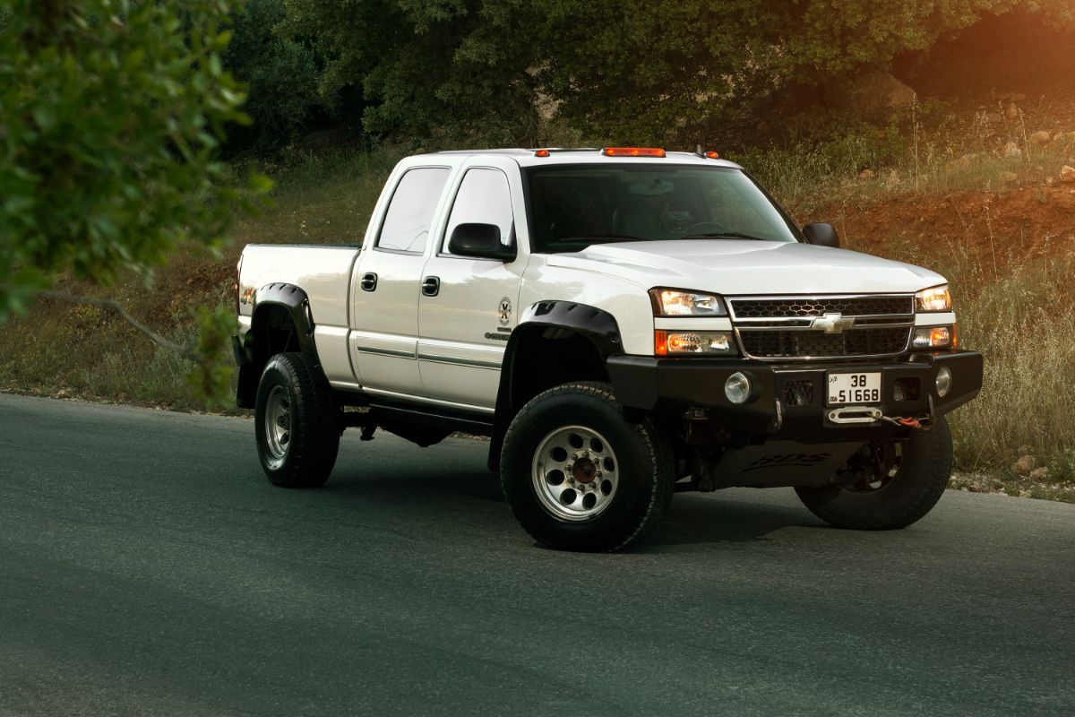 A white chevy silverado 2500 in the road.