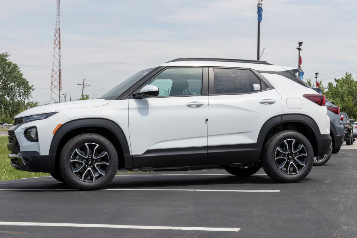 A white chevy trailblazer parked on a parking space.