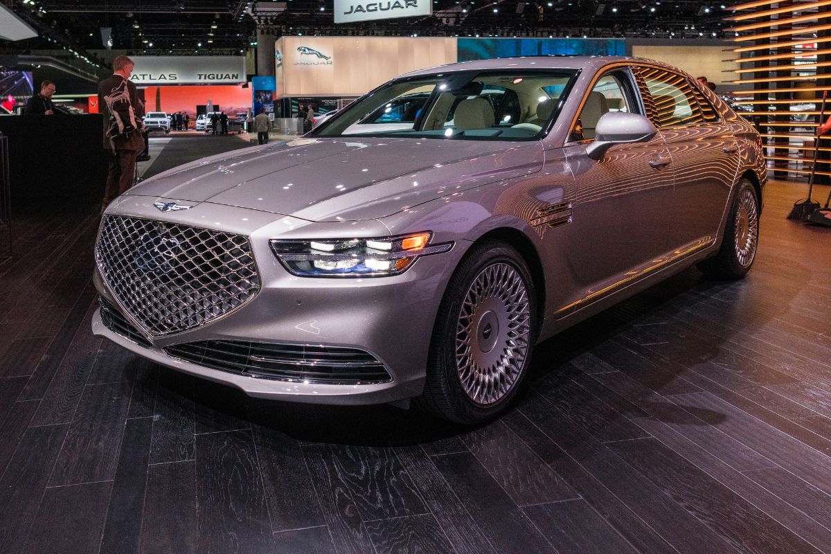 Front side view of a gray Genesis G90 on display.