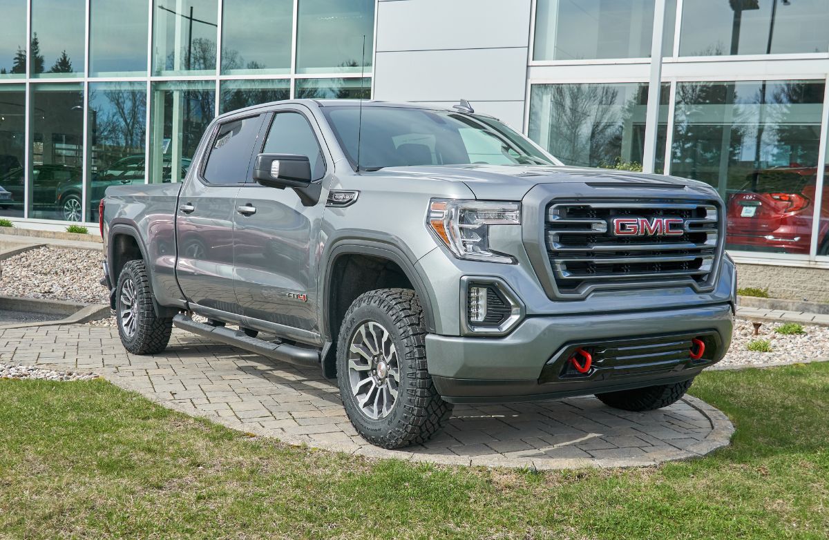 A front view of a gray 2022 GMC Canyon parked near a building.