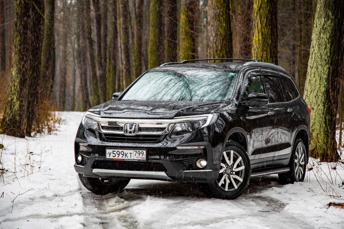 A black honda pilot in the forest winter season.