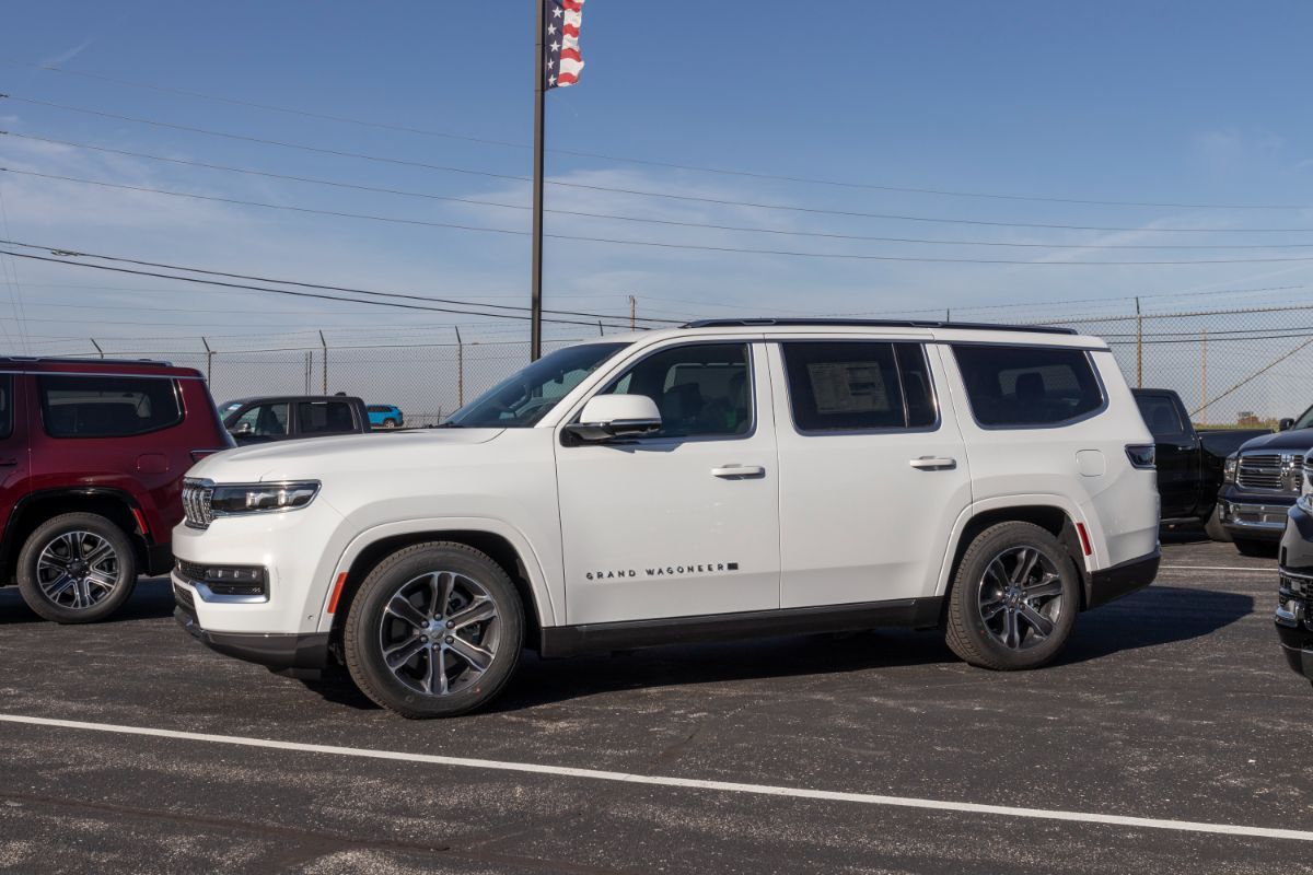 Side view of a white jeep wagonee in a parking space.