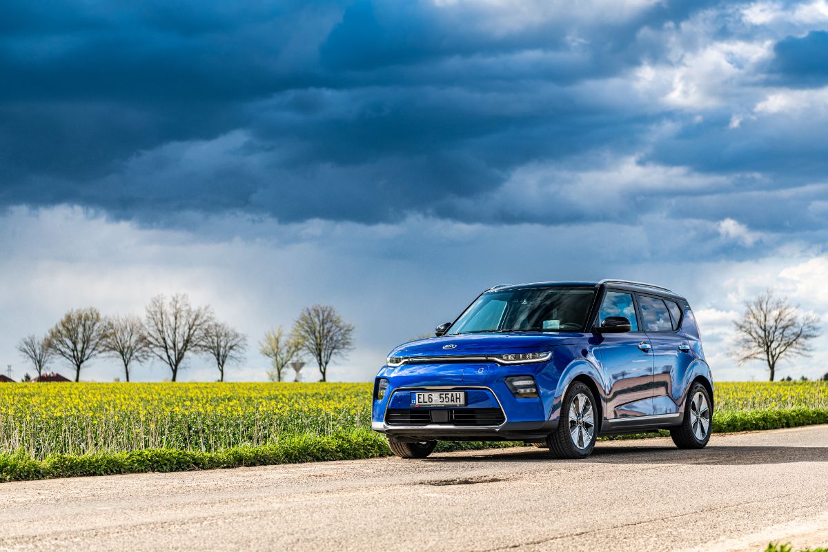 A photo of blue kia soul car on the road.