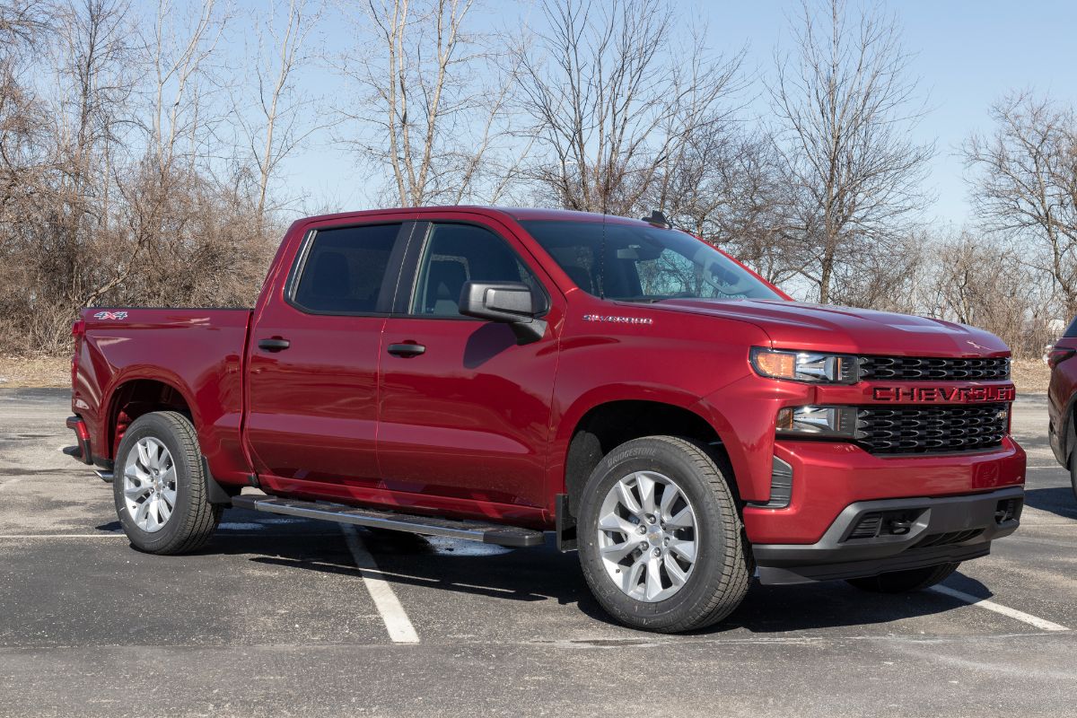 A side view of a maroon 2022 Chevrolet Silverado in parking area.