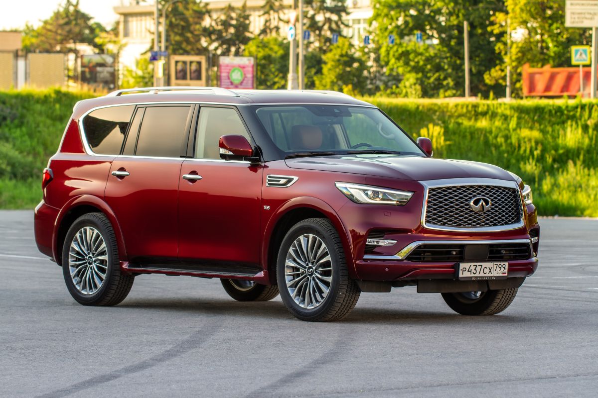 Side view of red Infiniti QX5 on road.