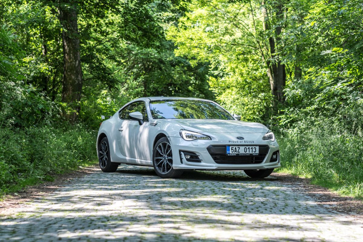 A white subaru brx in the forest photographed.