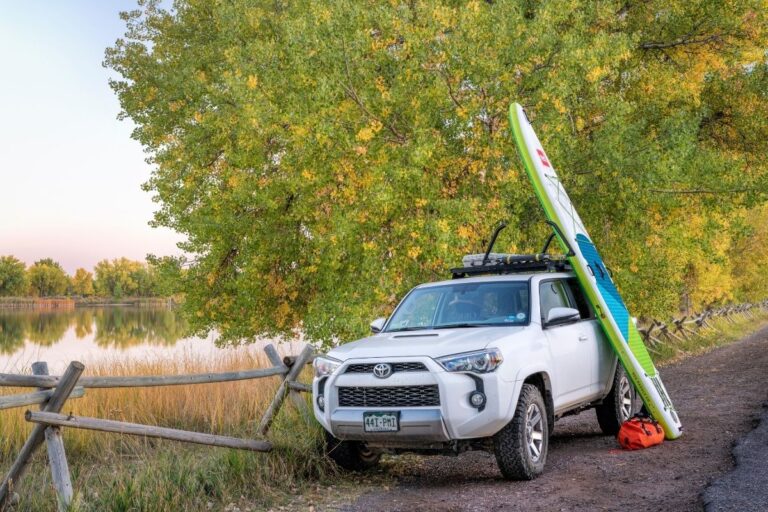 A white suv with paddleboard.