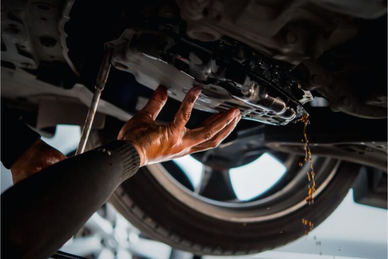 A man changing the transmission fluid.