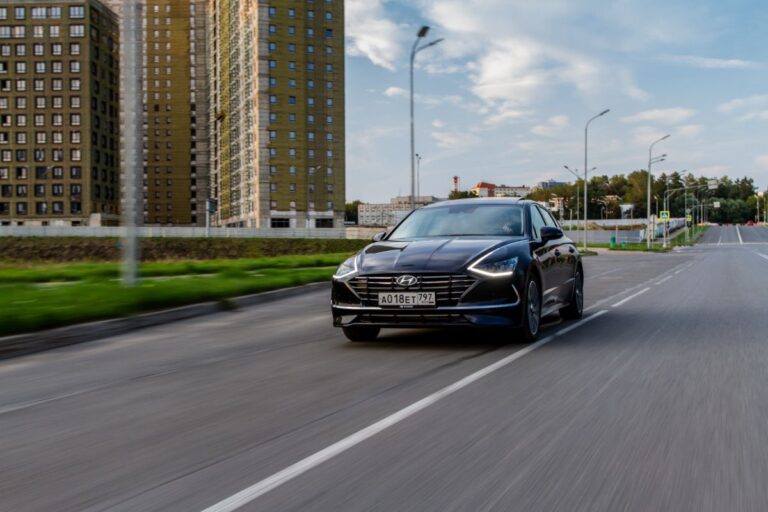 A black hyundai sonata driving in the empty road.